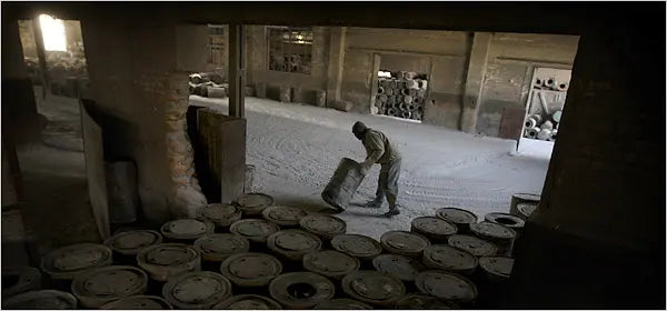Chinese workers can face serious work hazards and abuse. In Hebei Province in northern China, a worker dragged a barrel in a chemical factory.